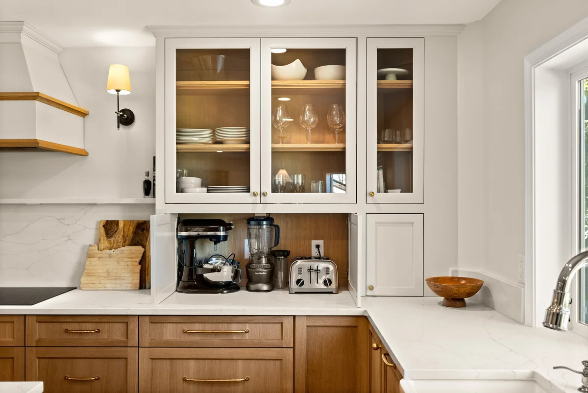 Glass-front upper cabinetry above wood base cabinets