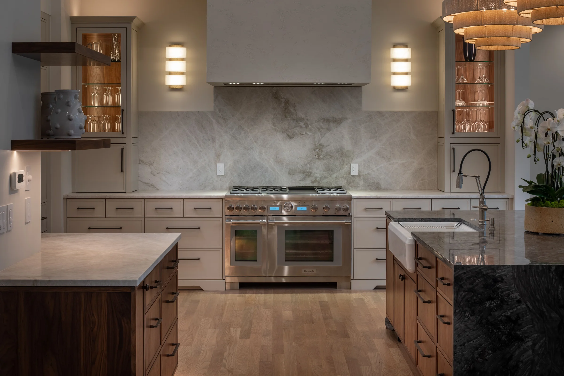 Custom gray kitchen cabinetry with a wood island and stone countertops